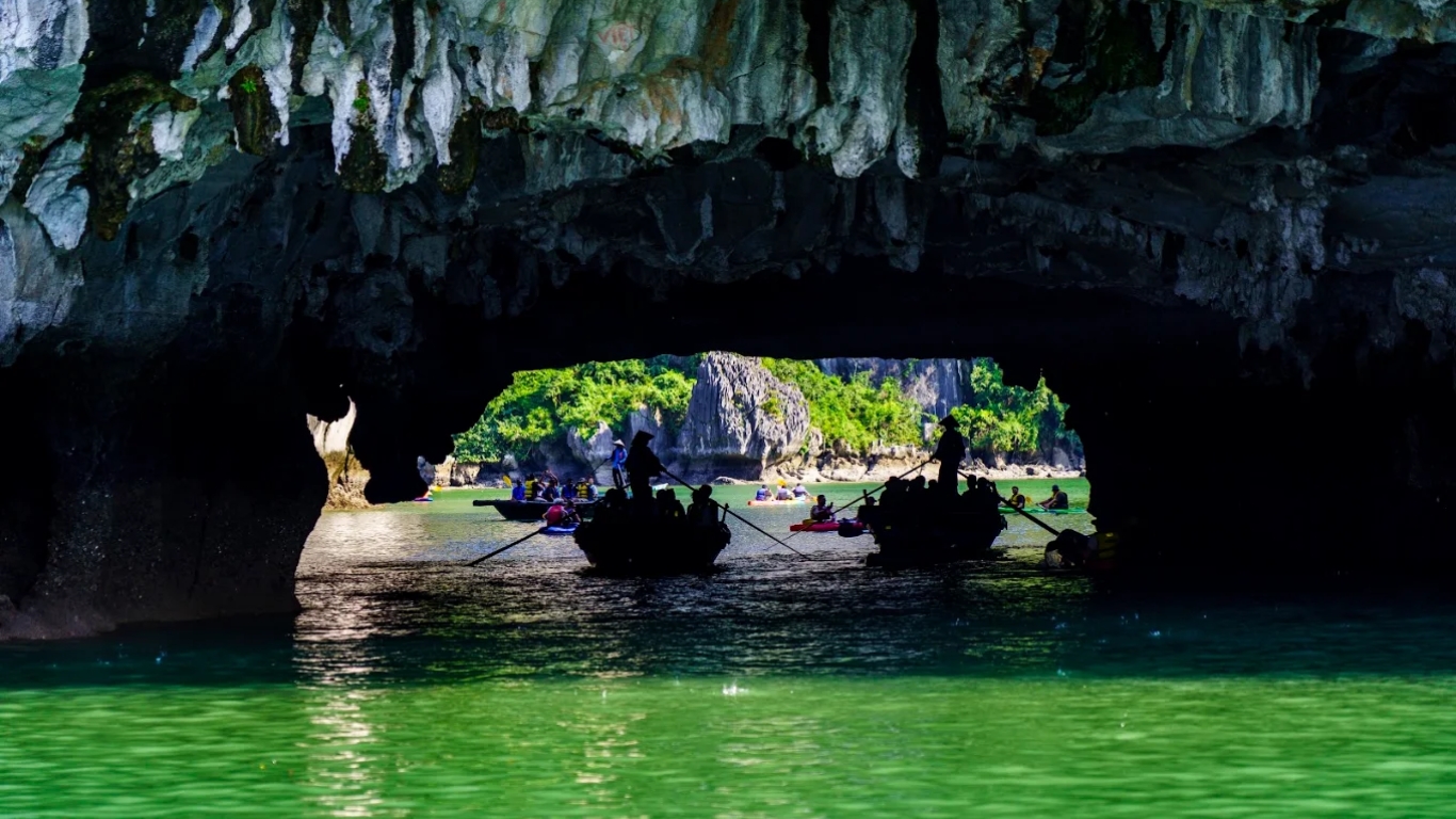 Traditional rowing boats passing through Cao Cave entrance to Vung Vieng Fishing Village Halong Bay