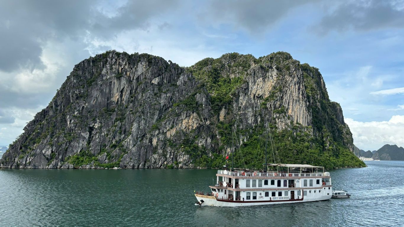 Halong Bay cruise ship sailing past limestone karst in September