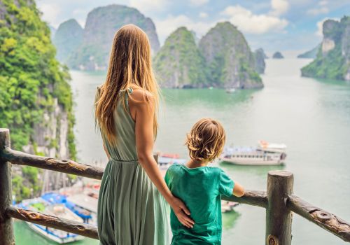 Parent and child enjoying the view of Halong Bay islands during a family trip