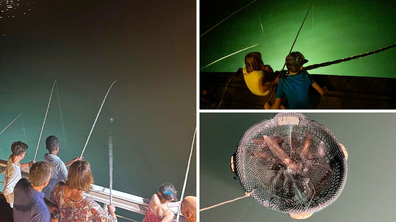 Tourists of different ages fishing for squid at night on a Halong Bay cruise deck, with fishing rods over glowing green lit water and a net full of freshly caught squid.