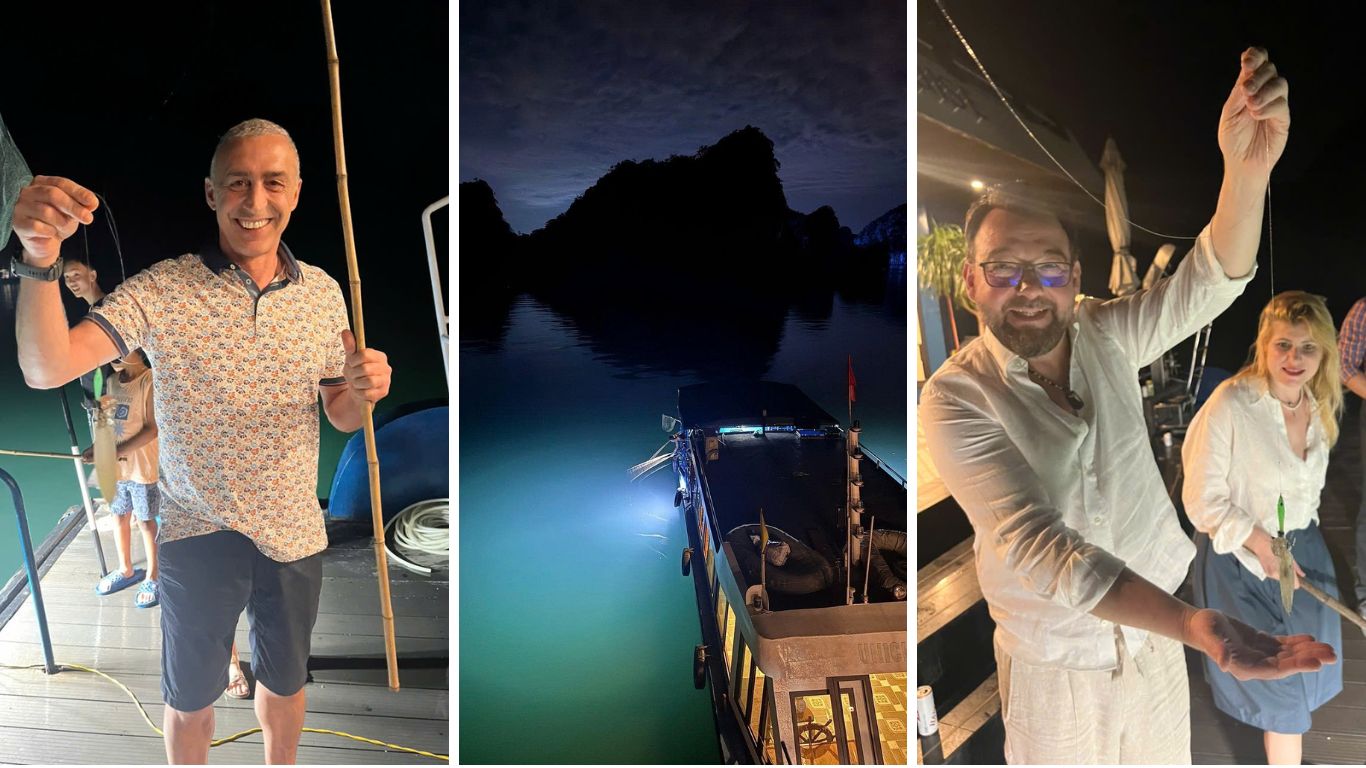 Tourists enjoying squid fishing at night on a cruise deck in Halong Bay, Vietnam, with limestone karsts silhouetted against the dark sky in the background.